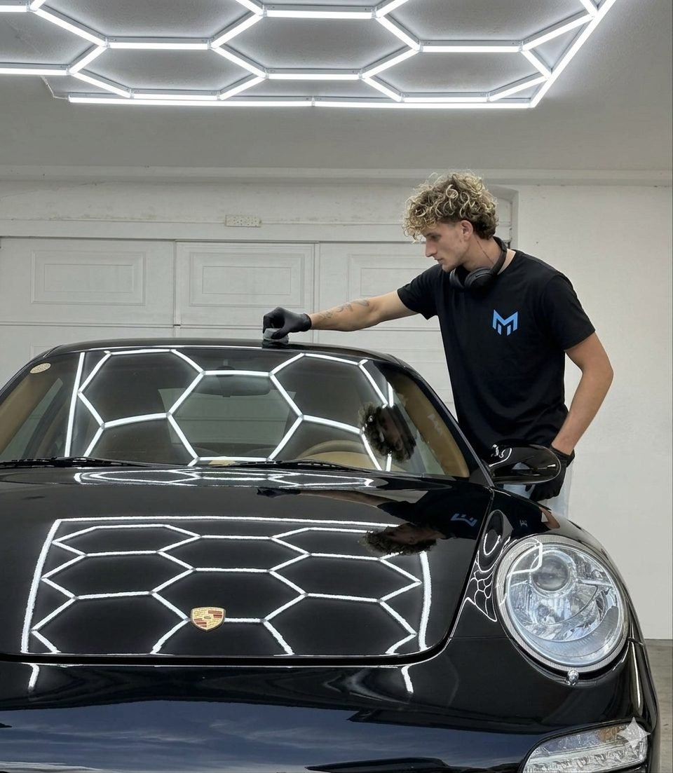 Matteo, fondateur de MC Detailing, polissant une Porsche 911 noire